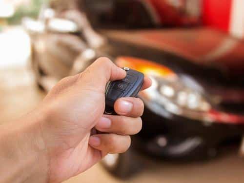 A locksmith in Huntsville, AL checking that a new key fob is working to open a vehicle. Our automotive locksmiths don't just open your car, they can replace car keys.